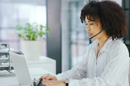 woman at computer wearing headset